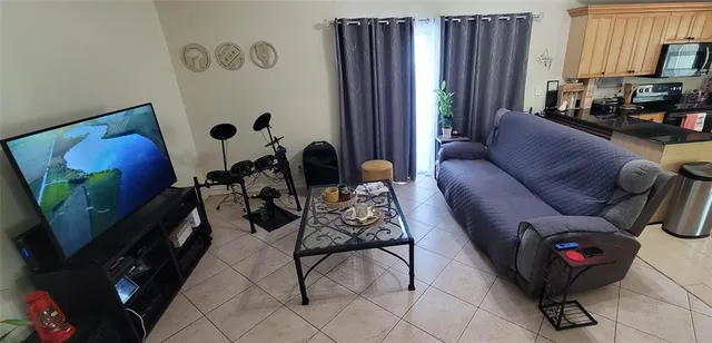 a living room with furniture a window and a flat screen tv