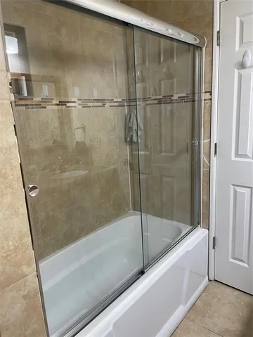 a bathroom with a shower and a bath tub
