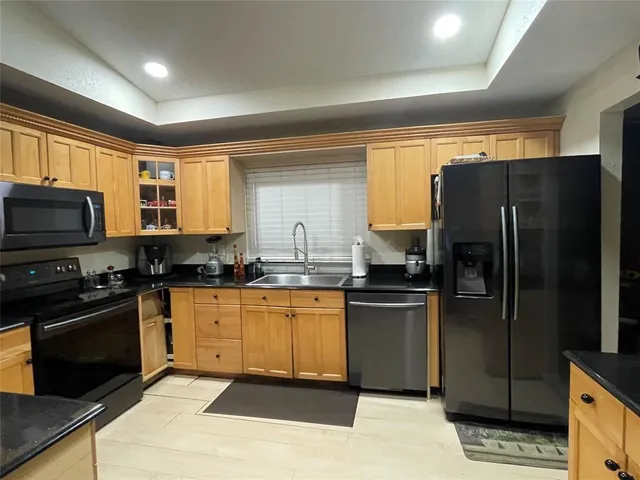 a kitchen with stainless steel appliances granite countertop a sink stove and refrigerator