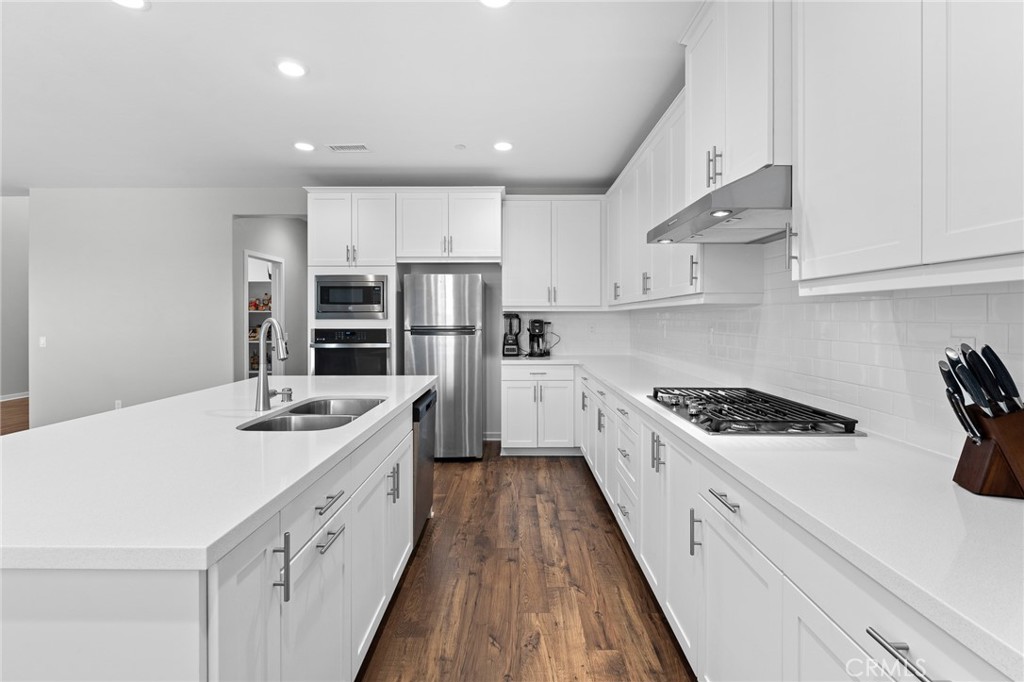 36772 Arietta Way Beaumont, CA 92223 - Photo 13 of 45 a kitchen with white cabinets sink and stainless steel appliances