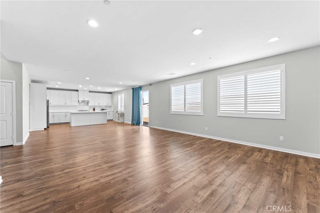 36772 Arietta Way Beaumont, CA 92223 - Photo 18 of 45 a view of an empty room with a window and wooden floor