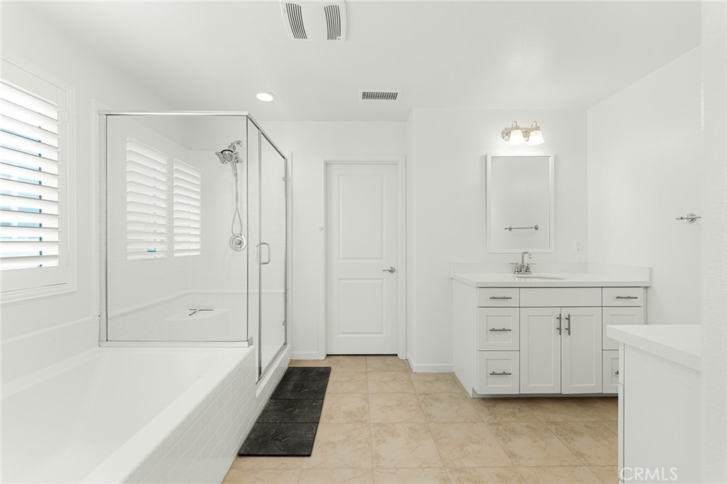 36772 Arietta Way Beaumont, CA 92223 - Photo 41 of 45 a bathroom with a tub sink and mirror