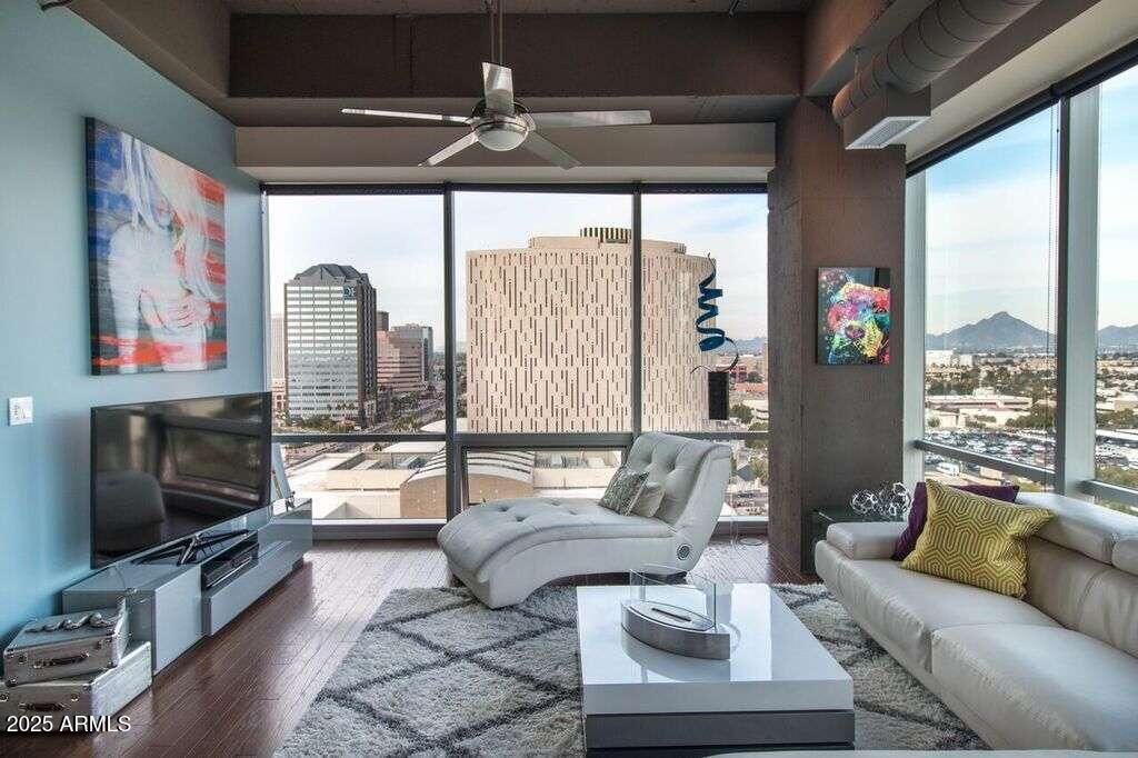 a living room with furniture a flat screen tv and a floor to ceiling window