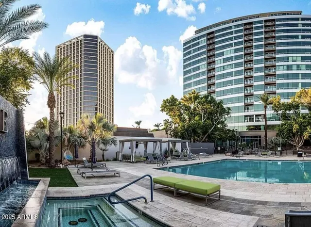 a living room with furniture floor to ceiling windows and wooden floor