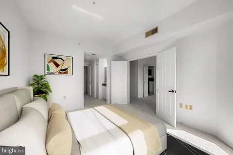 a bedroom with a bed and painting on the wall