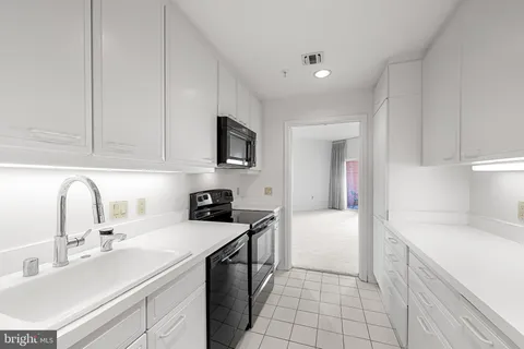 a kitchen with stainless steel appliances a stove a microwave a sink and cabinets