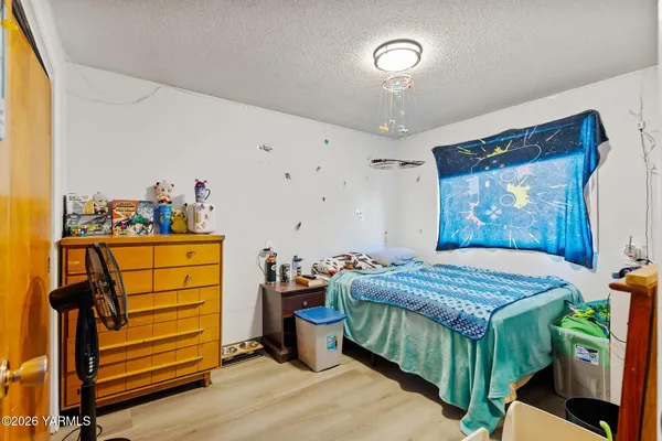 a kitchen with stainless steel appliances a stove a sink a refrigerator white cabinets and wooden floor