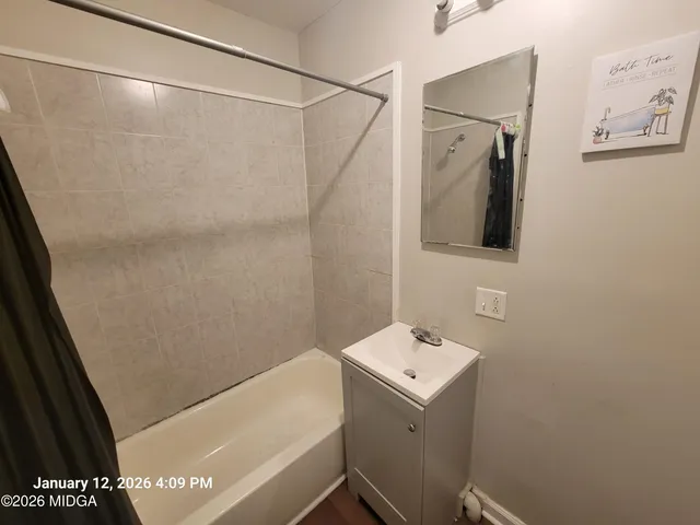a bathroom with a sink and mirror with bathtub