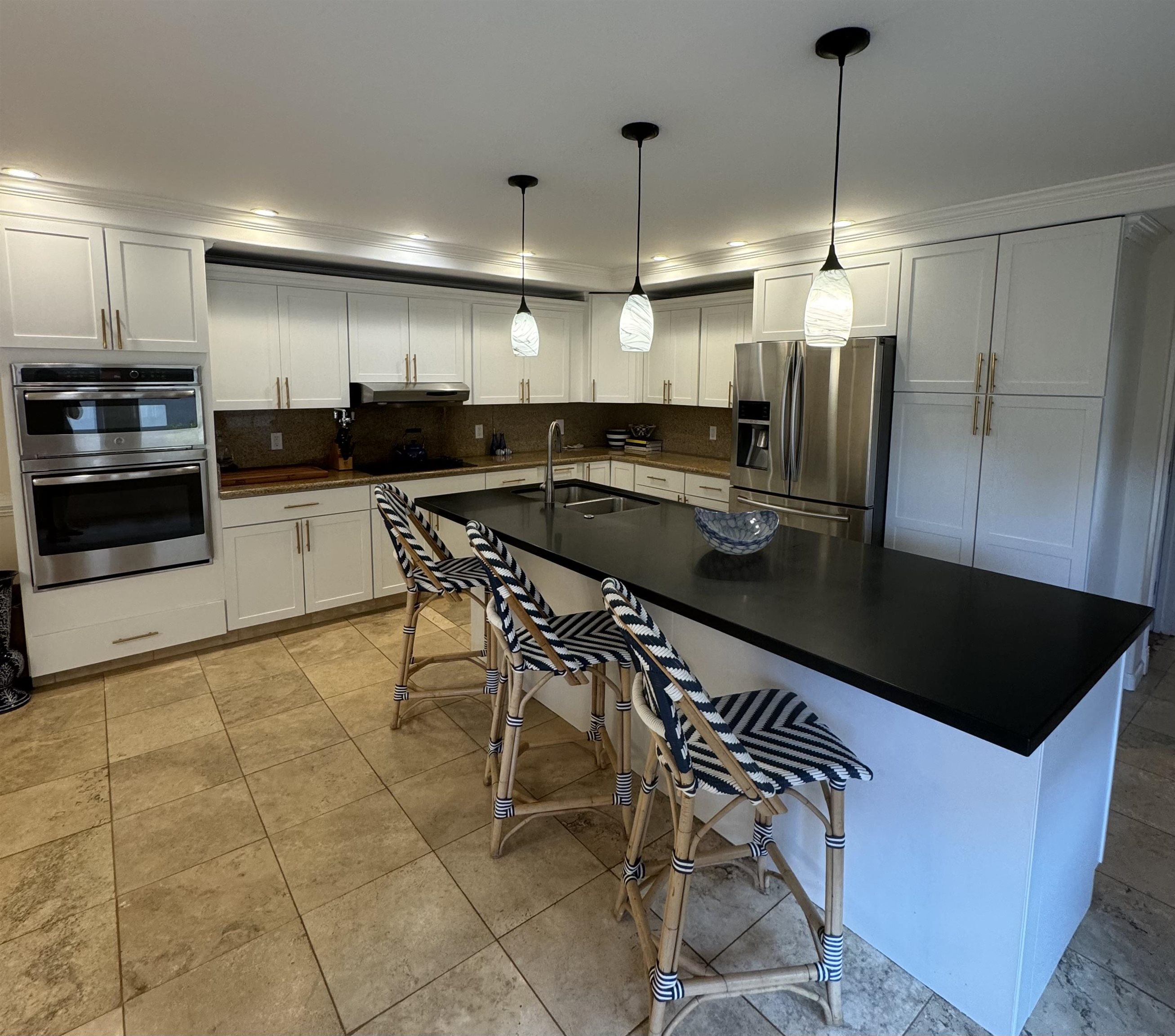a kitchen with stainless steel appliances granite countertop a stove a refrigerator a sink and a granite counter tops