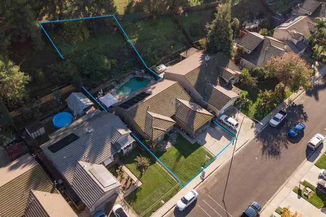 an aerial view of a house with garden space and street view