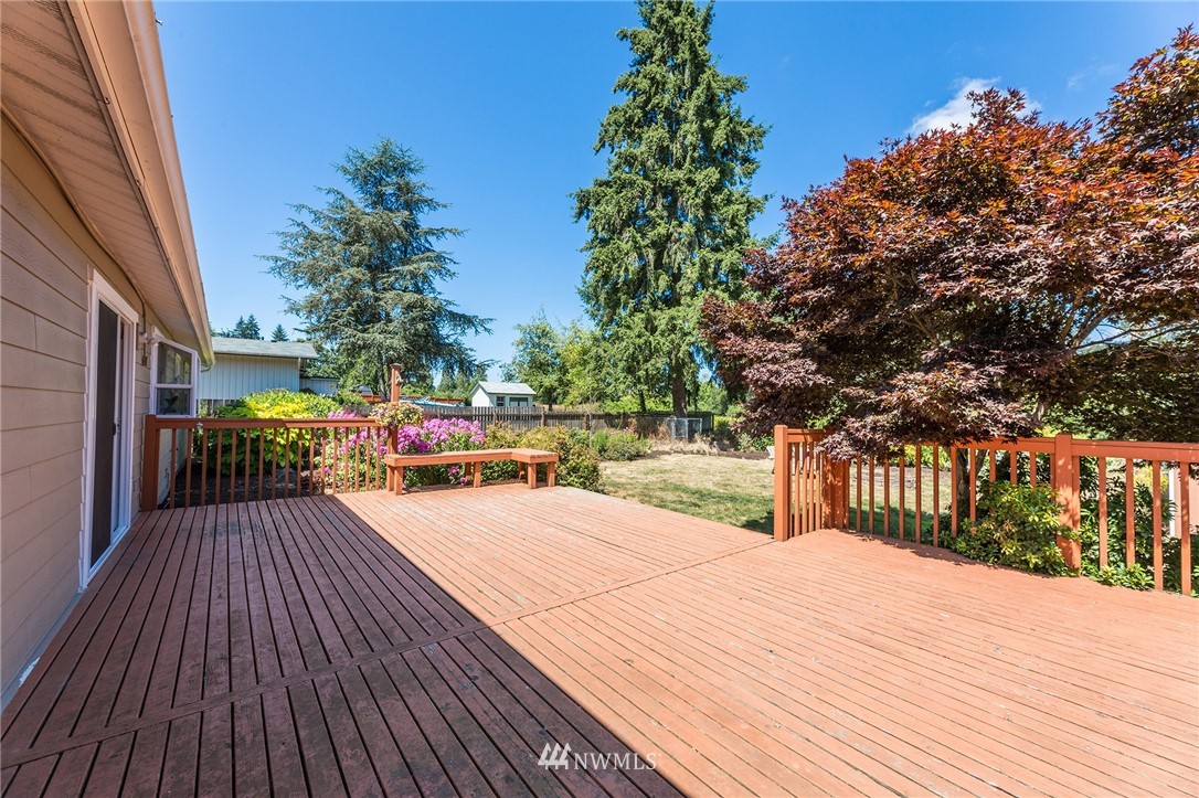 17810 Southeast 121st Place Renton, WA 98059 - Photo 18 of 23 a patio with table and chairs and a barbeque with wooden fence and trees