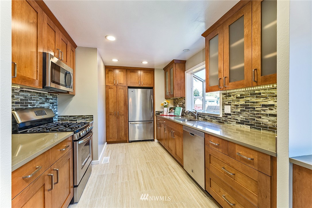 17810 Southeast 121st Place Renton, WA 98059 - Photo 8 of 23 a kitchen with stainless steel appliances granite countertop a stove a sink and a refrigerator