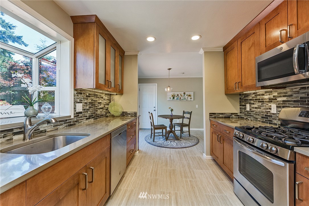 17810 Southeast 121st Place Renton, WA 98059 - Photo 10 of 23 a kitchen with stainless steel appliances a stove sink microwave and cabinets