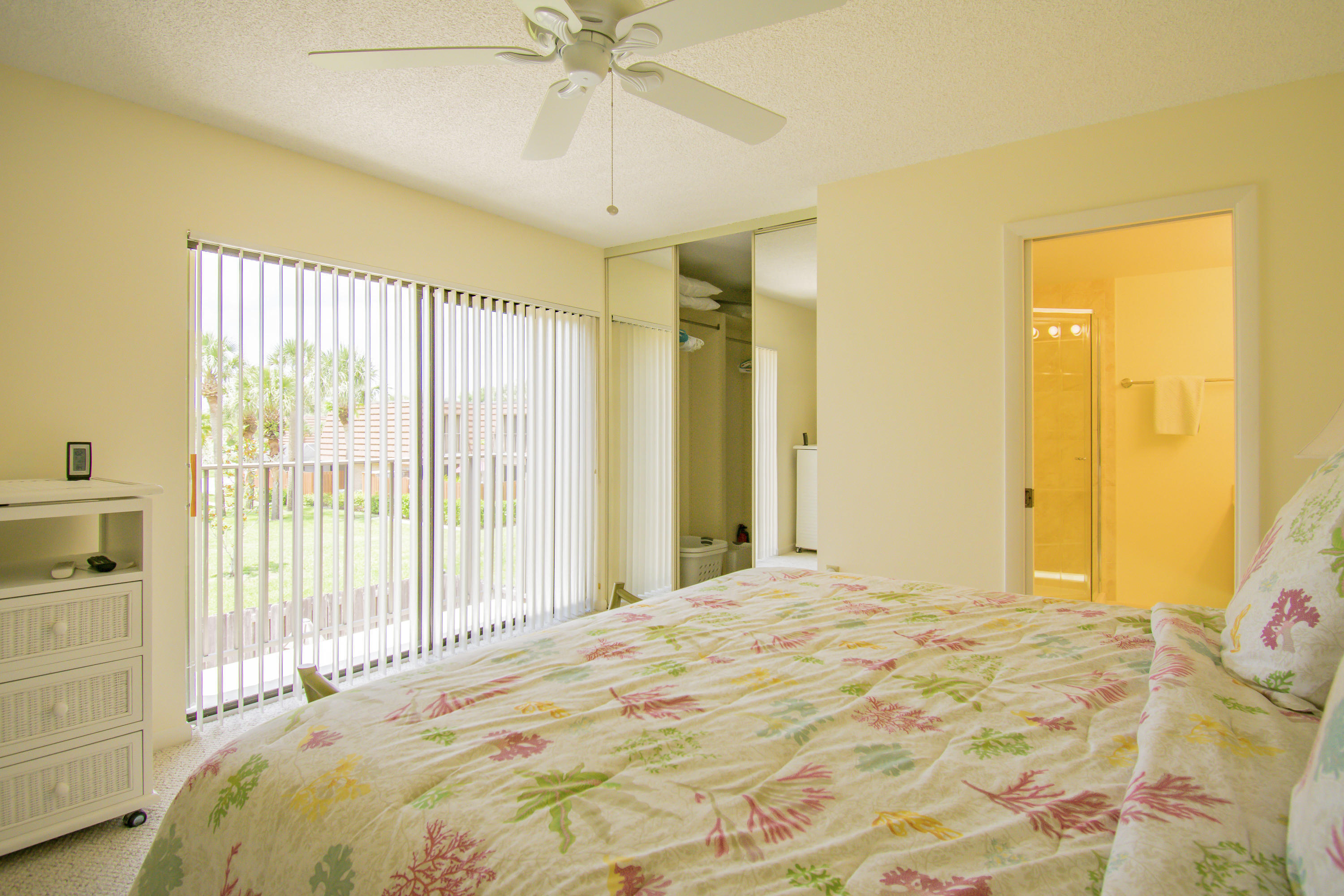 2410 24th Court Jupiter, FL 33477 - Photo 12 of 33 a bedroom with a large bed and a chandelier