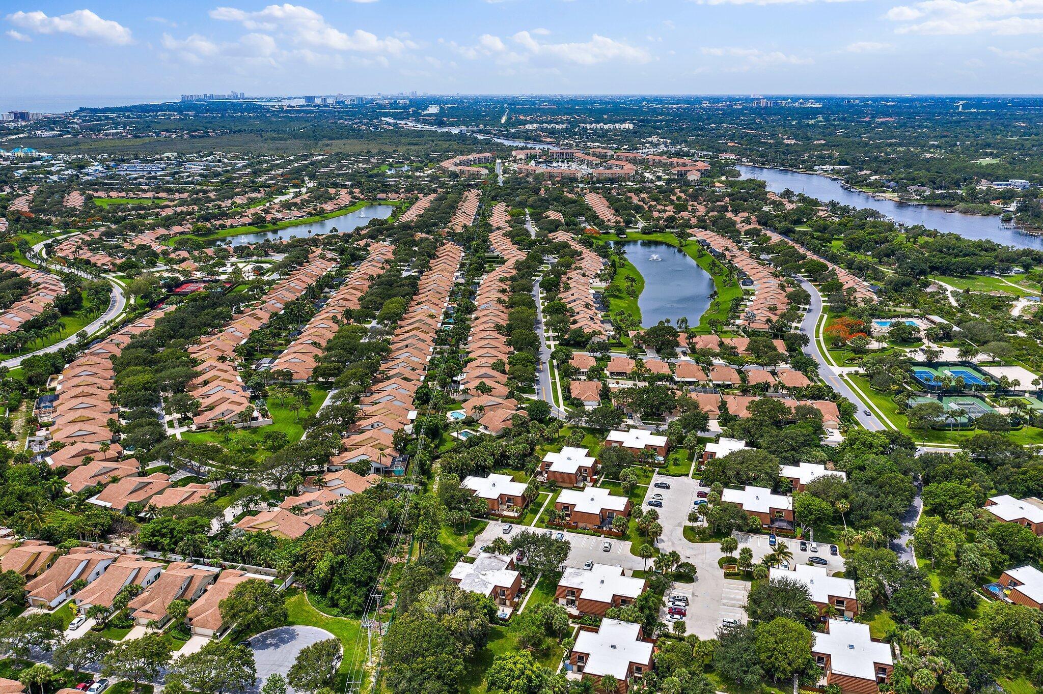2410 24th Court Jupiter, FL 33477 - Photo 27 of 33 an aerial view of residential houses with outdoor space and trees