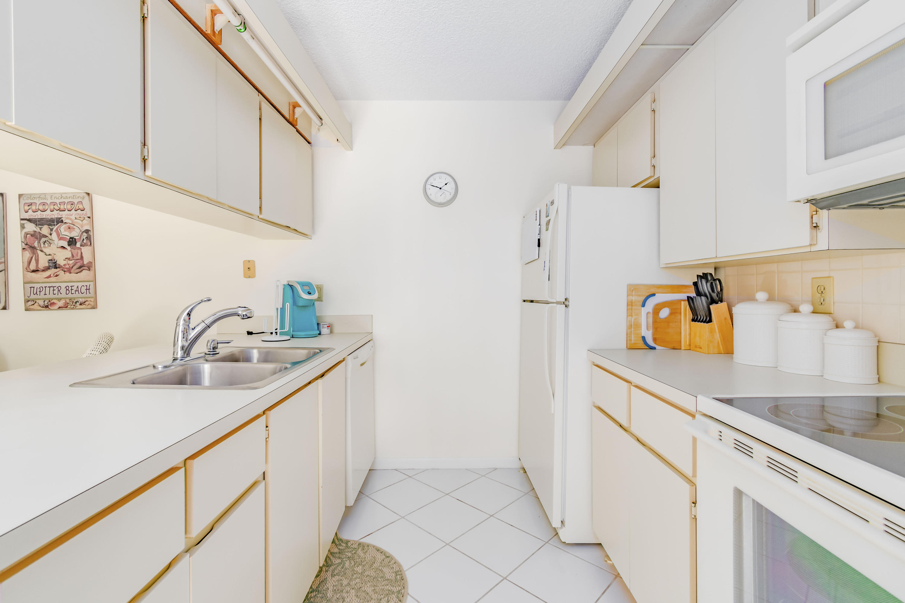 2410 24th Court Jupiter, FL 33477 - Photo 5 of 33 a kitchen with a sink and a refrigerator