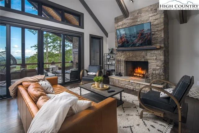 a living room with furniture fireplace and a large window