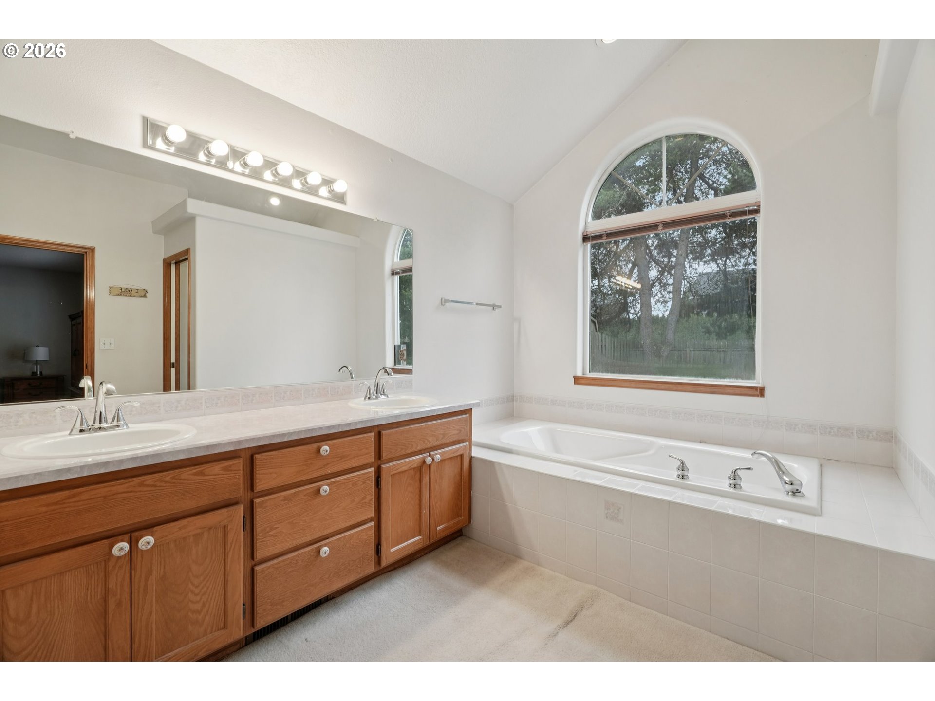 19862 Castleberry Loop Oregon City, OR 97045 - Photo 19 of 33 a bathroom with a double vanity sink a large mirror a bathtub and a window