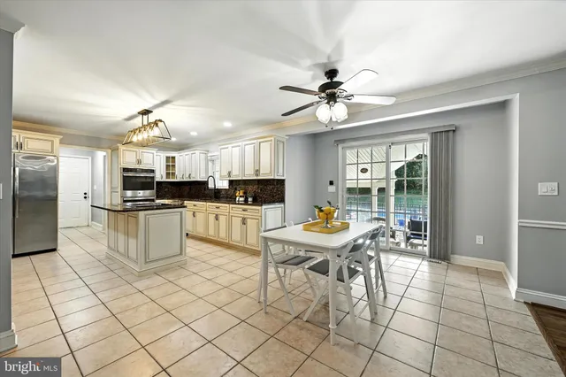 a kitchen with stainless steel appliances granite countertop a stove a sink dishwasher a dining table and chairs with wooden floor