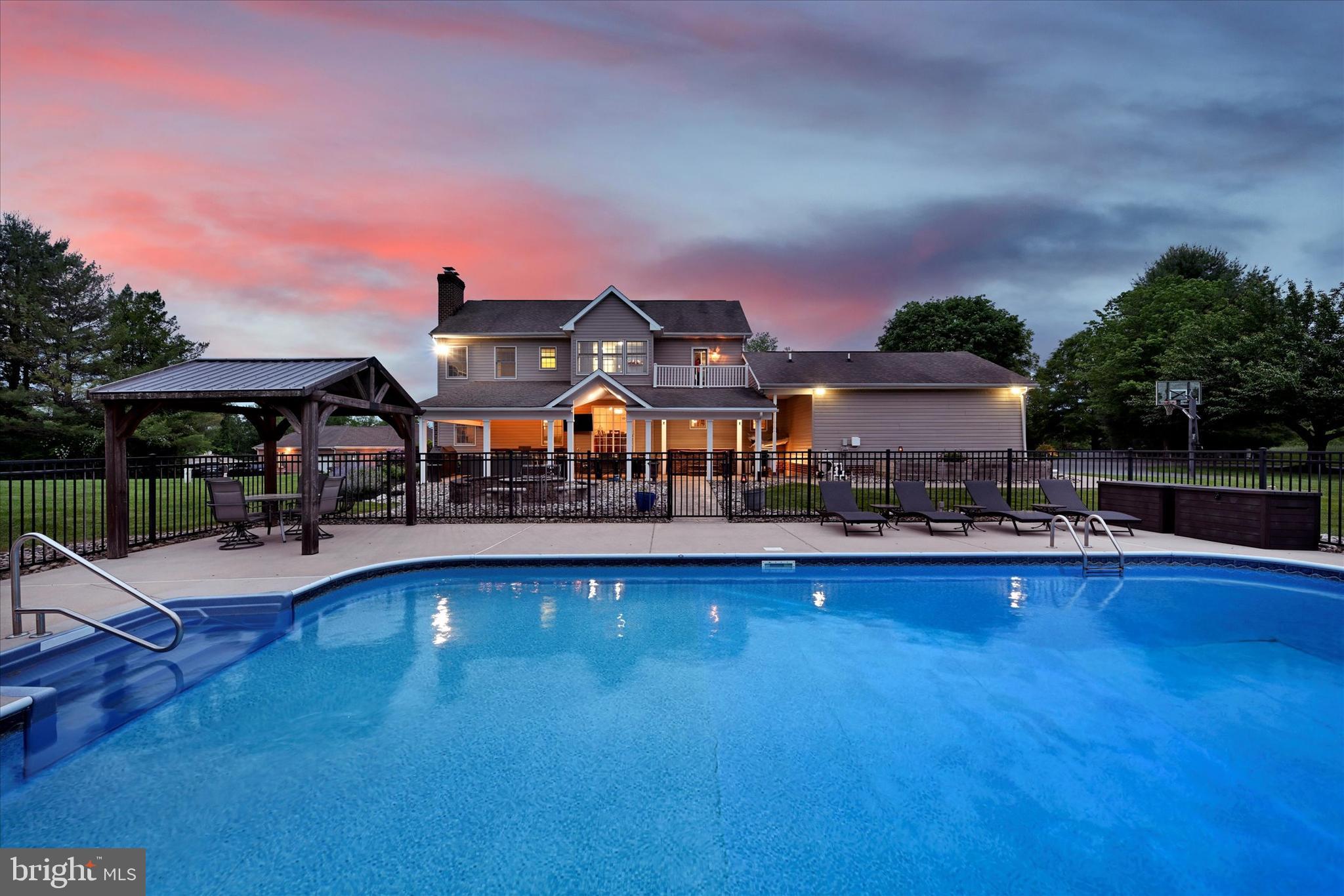 1014 Bernoudy Road White Hall, MD 21161 - Photo 64 of 73 a view of a swimming pool with lawn chairs under an umbrella