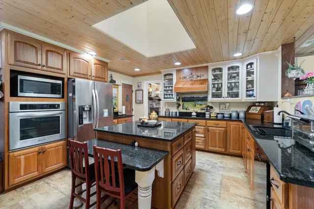 a kitchen with stainless steel appliances granite countertop a stove a sink dishwasher a microwave oven with granite countertops and cabinets