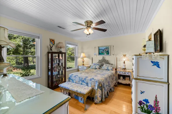 a bedroom with a bed a large window with flat screen tv and a couch