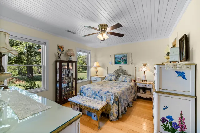 a bedroom with a bed a large window with flat screen tv and a couch