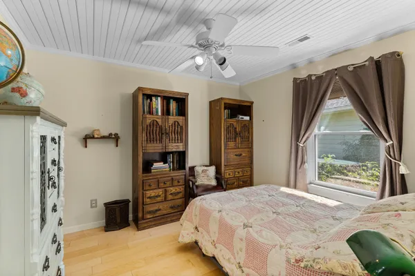 a bedroom with a bed and wooden floor