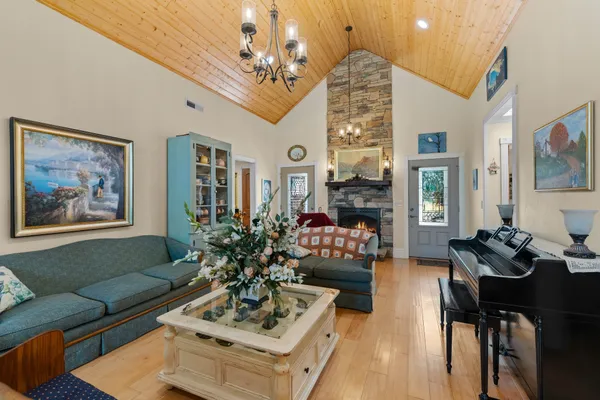 a living room with furniture a chandelier and a fireplace
