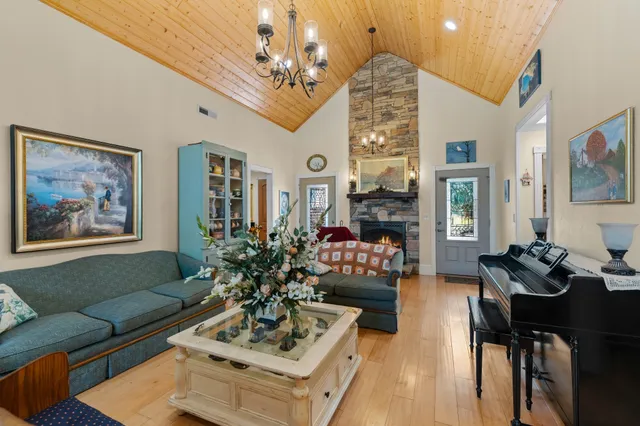 a living room with furniture a chandelier and a fireplace