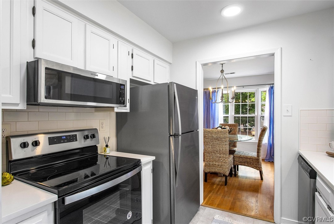 2734 Berkeley Pointe Drive Richmond, VA 23233 - Photo 10 of 31 a kitchen with stainless steel appliances a stove a refrigerator cabinets and a dining table