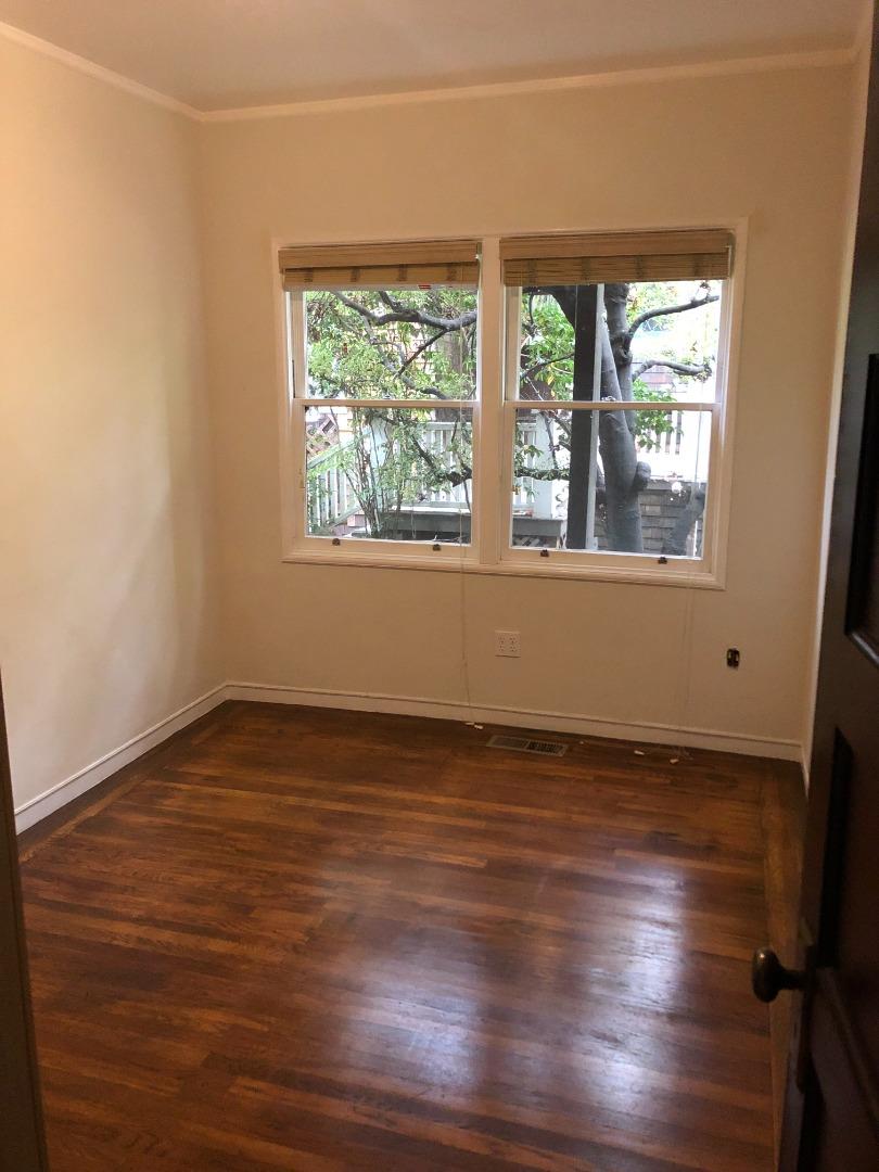2629 Piedmont Avenue, Unit E Berkeley, CA 94704 - Photo 8 of 14 an empty room with wooden floor and windows