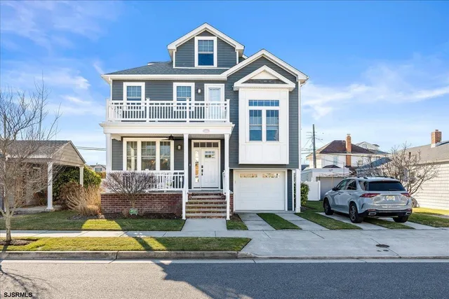 a front view of a house with a garden and parking