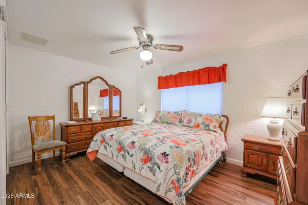 a bedroom with a bed and wooden floor