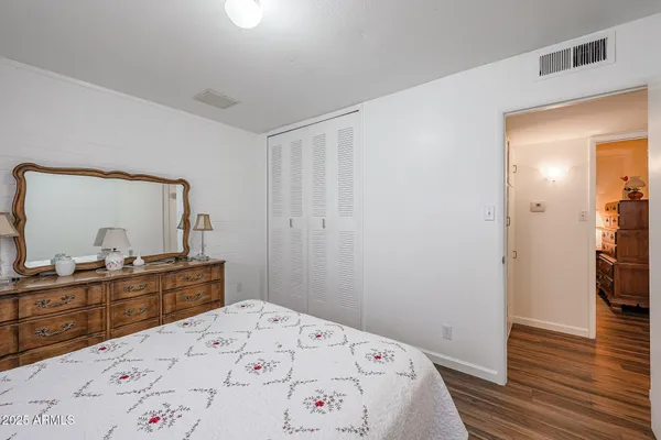 a bedroom with a bed and a dresser in it