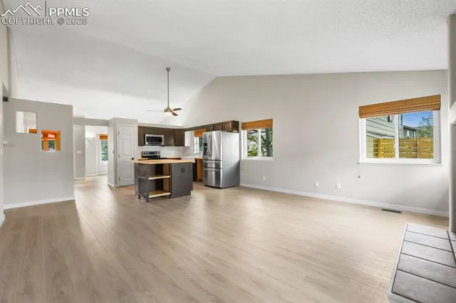 a view of a kitchen with furniture and wooden floor