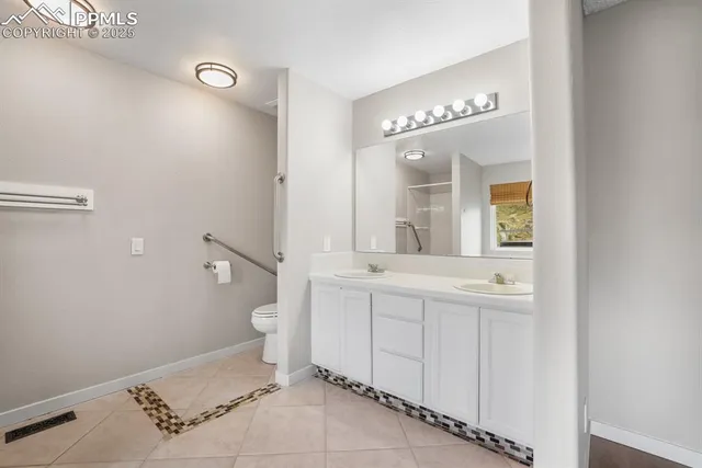 a spacious bathroom with a toilet a sink and mirror