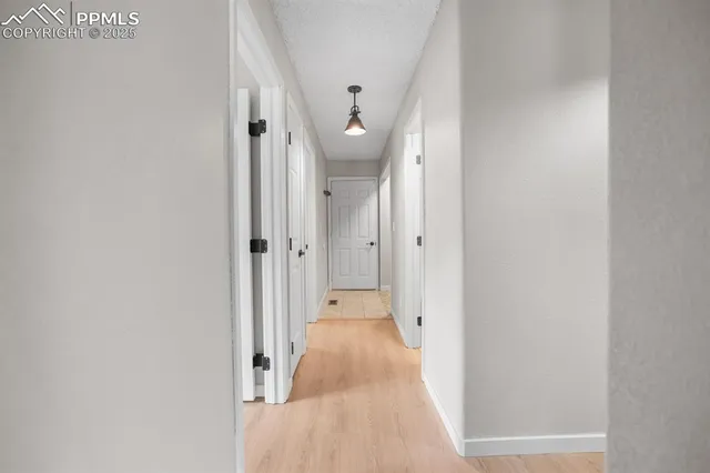 a view of a hallway with wooden shelves