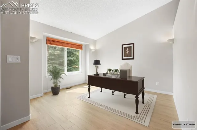 a view of a workspace with furniture and a window