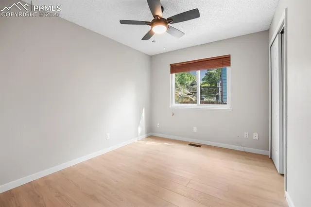 an empty room with a window and a fan