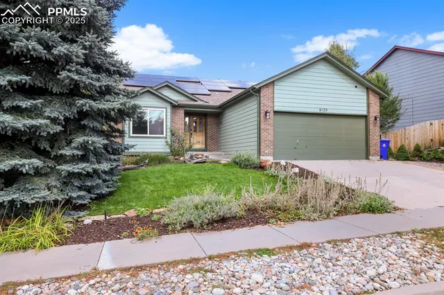 a front view of a house with a yard and potted plants