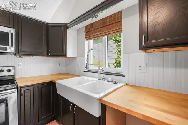 a kitchen with a sink dishwasher a stove and a microwave oven with cabinets