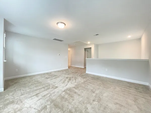 an empty room with windows and ceiling fan view