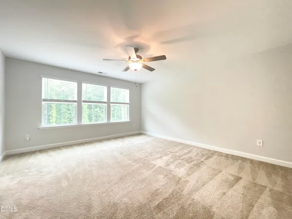 an empty room with closet and a ceiling fan