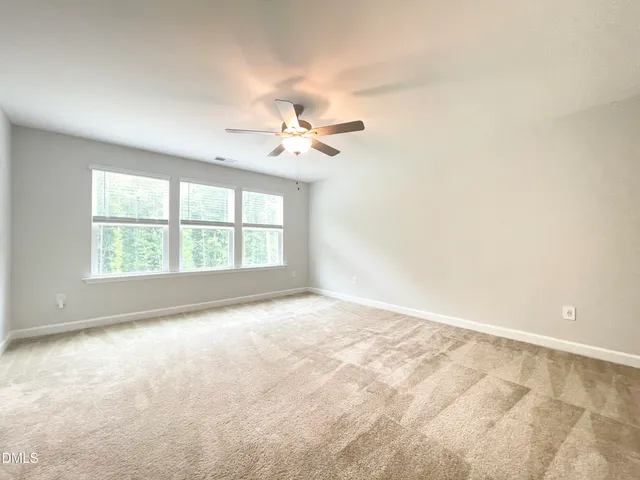 an empty room with closet and a ceiling fan