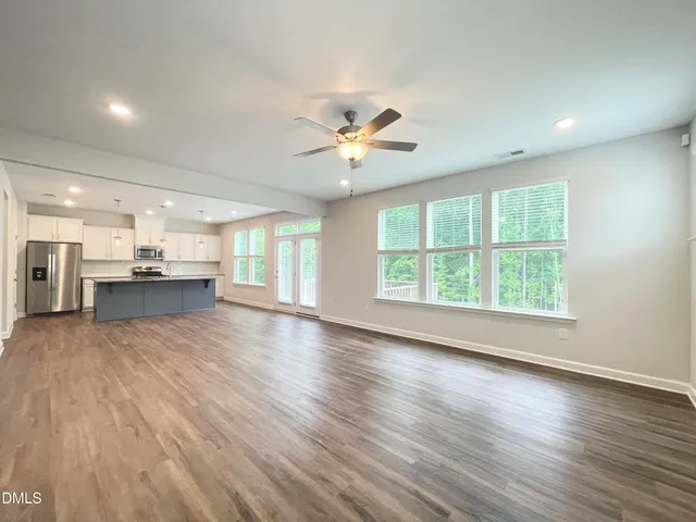 wooden floor in an empty room with a kitchen