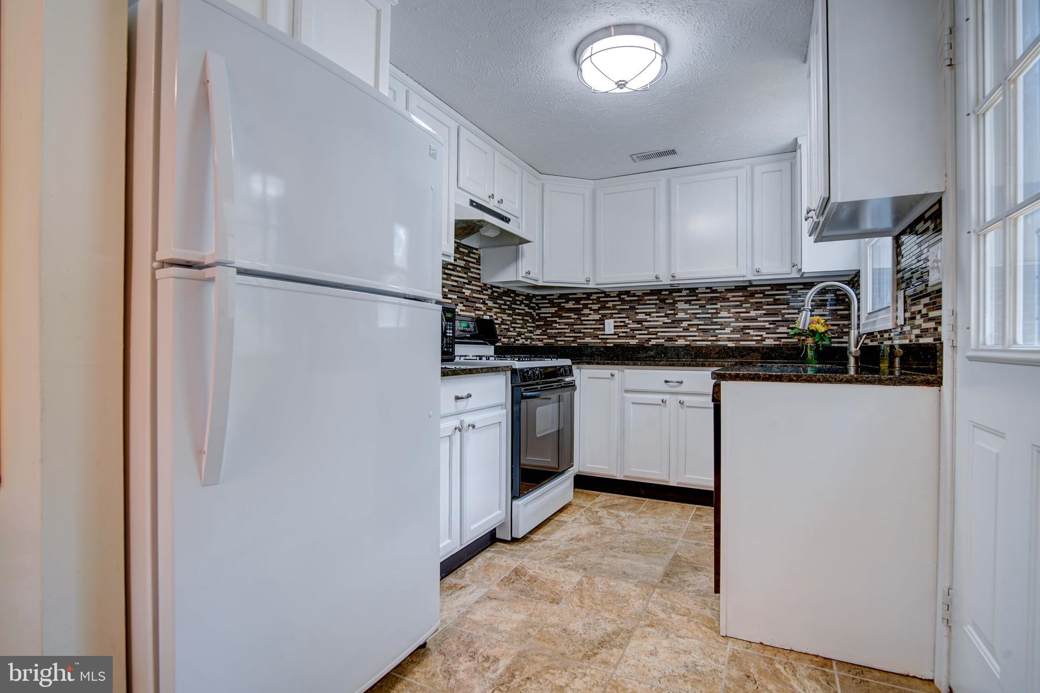 245 Newtown Road Solomons, MD 20688 - Photo 10 of 26 a kitchen with a sink stove and refrigerator