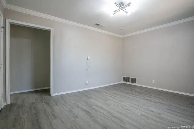 a view of an empty room with wooden floor