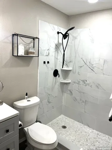 a bathroom with a toilet sink and shower