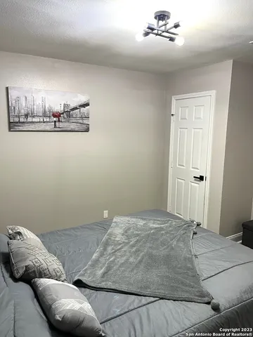 a bedroom with a bed and chandelier